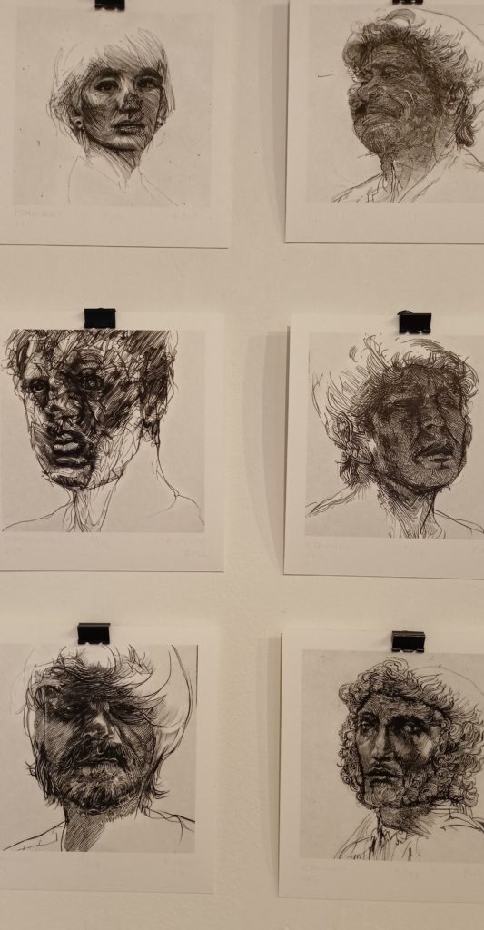 twarze ludzkie narysowane czarną kredką