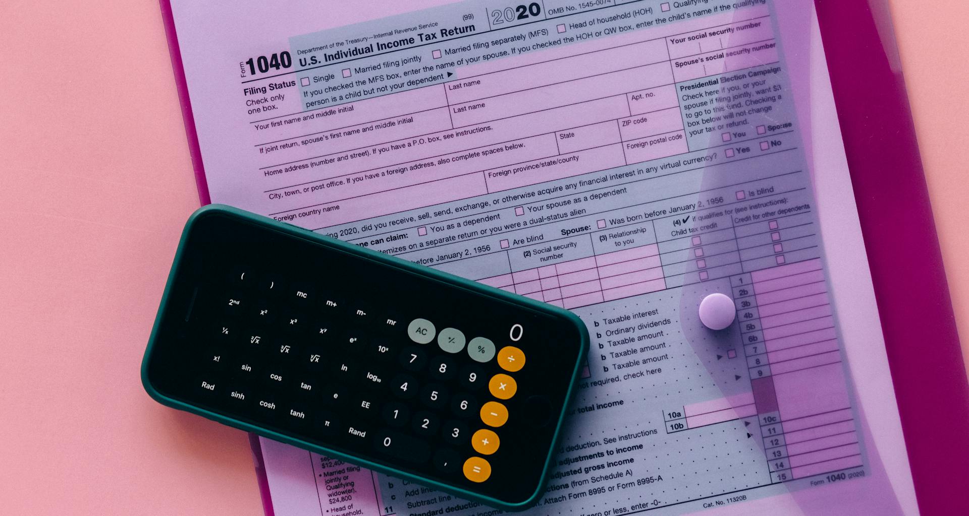 Tax form 1040 with a calculator on a pink background, highlighting finance and accounting themes.